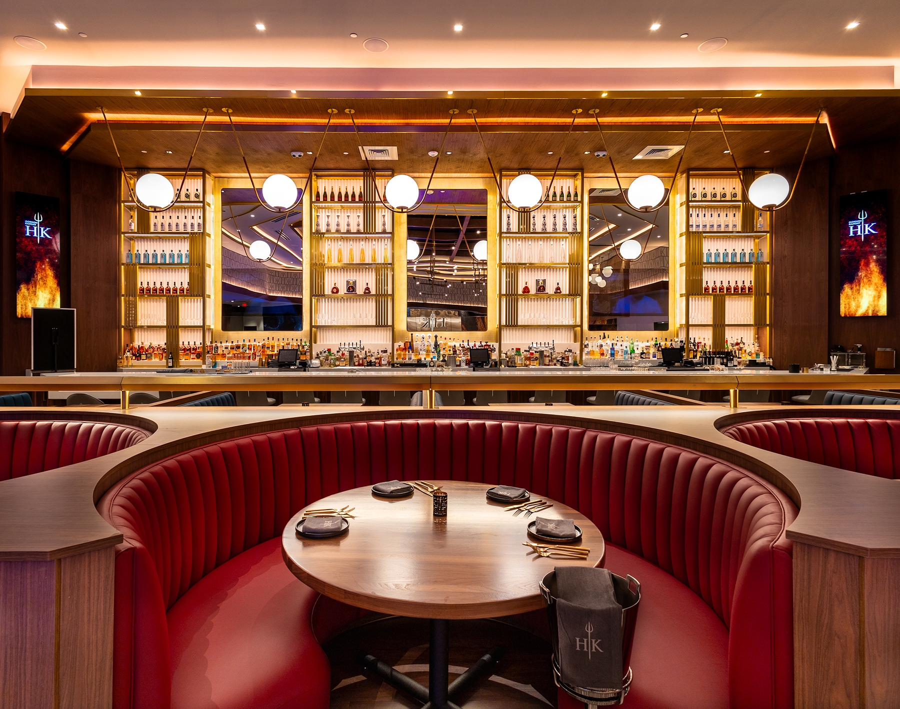 Photo showing booth seating with bar area in the background at Hell's Kitchen Foxwoods