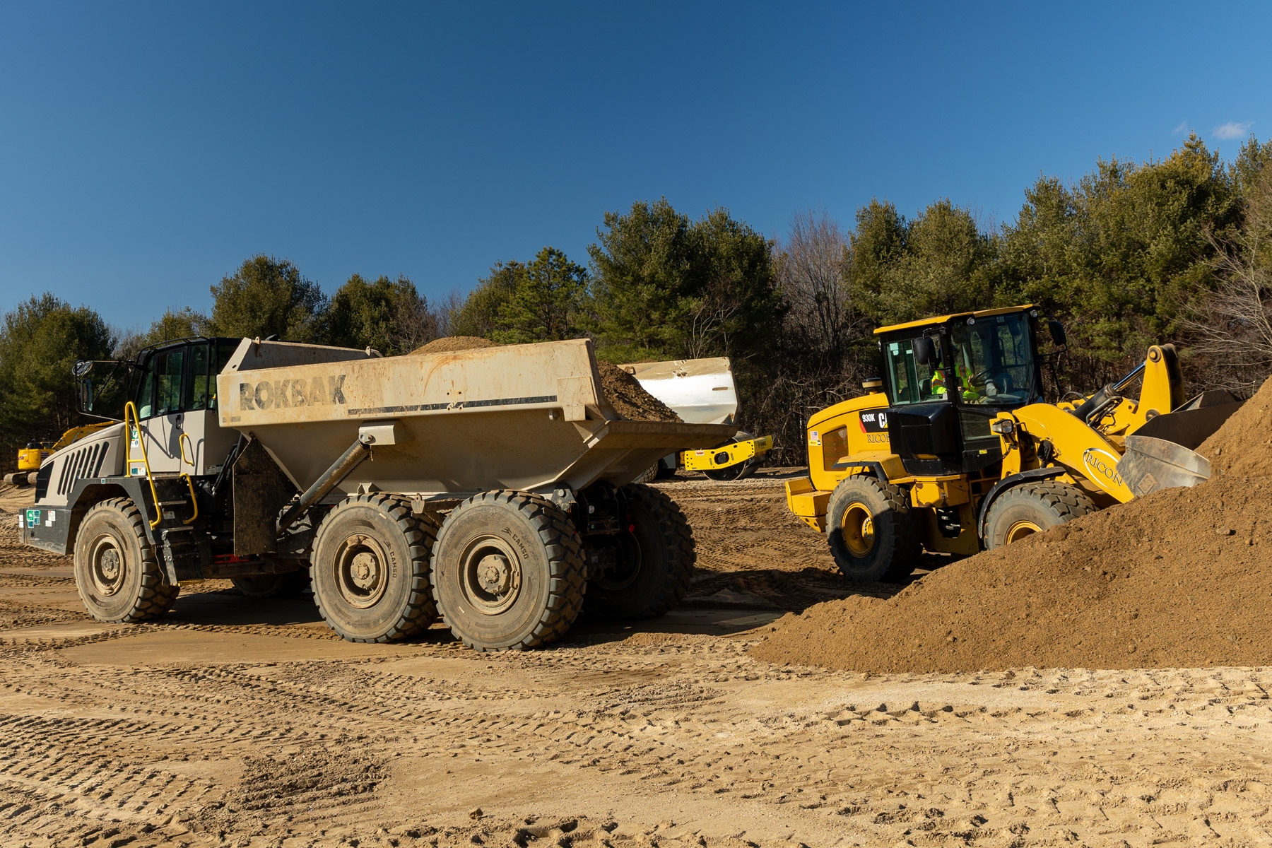 Rock truck and front loader prepping site