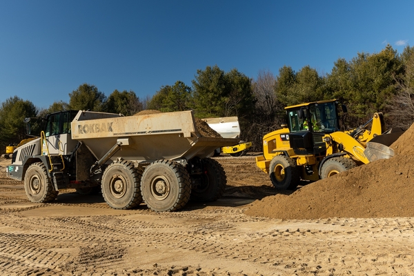 Rock truck and front loader prepping site
